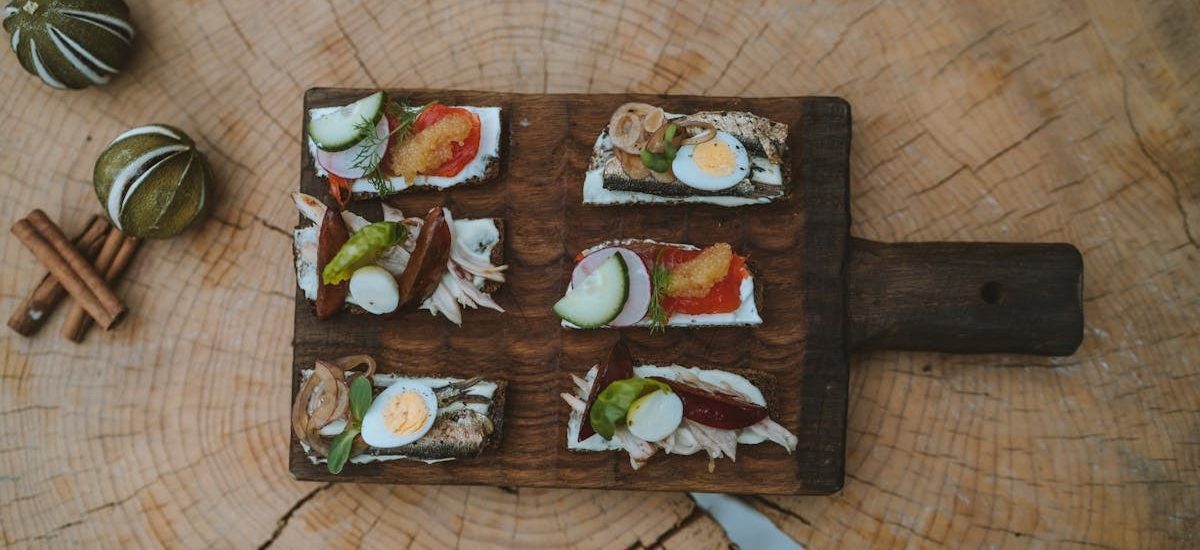 Top view of holiday appetizers on a wooden board with festive elements, creating a cozy rustic feel.