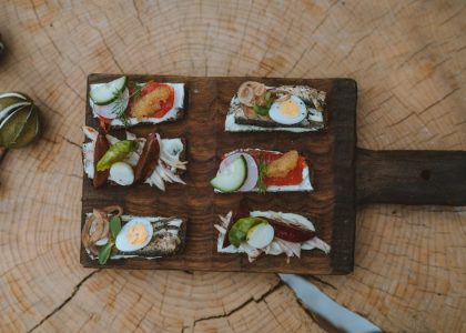 Top view of holiday appetizers on a wooden board with festive elements, creating a cozy rustic feel.